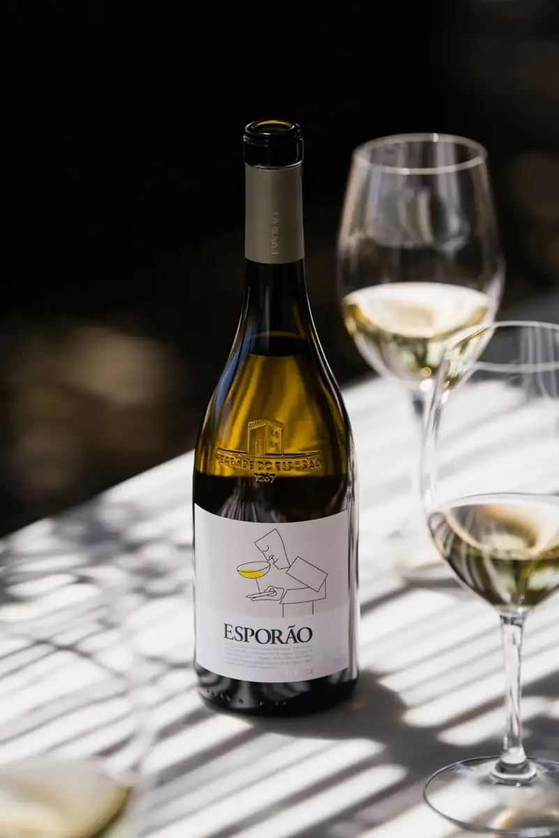 Garrafa de Esporão Reserva branco e copos de vinho à mesa